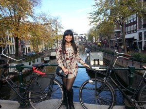 GIrl wearing black boots posing in front of bicycle in Amsterdam canal