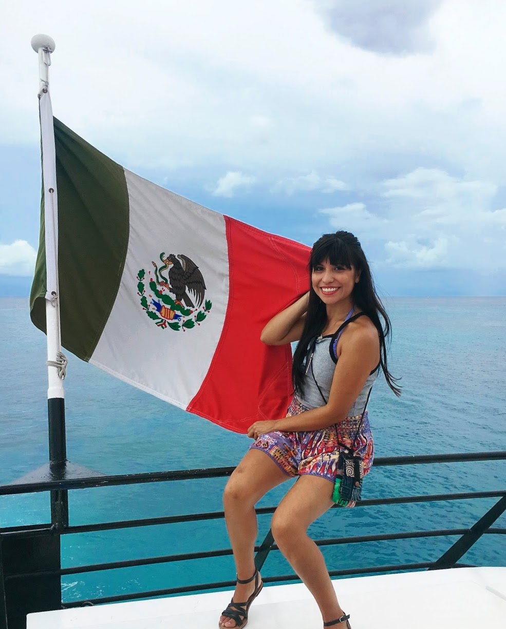 Girl on a ferry holding a Mexican flag.